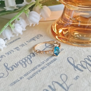 Macro di un anello vintage in argento S925 con topazio blu su sfondo rétro elegante