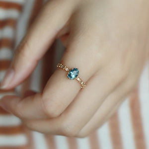 Dettaglio dell'anello con topazio blu di Londra con taglio marquise e piccoli diamanti sulla mano