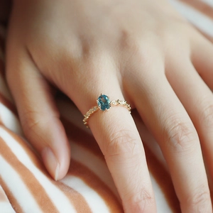 Macro dettagliata di un anello vintage in argento con topazio blu e piccoli diamanti
