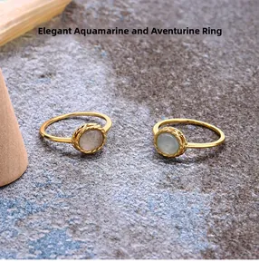 Nahaufnahme der Aquamarin und Labradorit Ringe mit gewebtem Goldrand auf Steinhintergrund