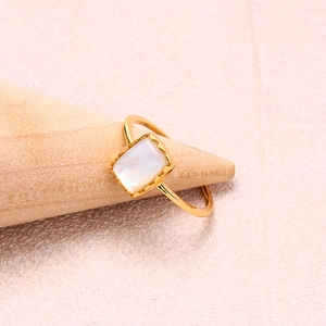 Bague en argent S925 doré avec nacre blanche rectangulaire sur un support en bois
