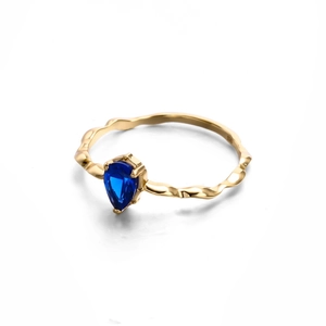Detalle del sello S925 en anillo dorado ondulado con circón de zafiro en forma de pera