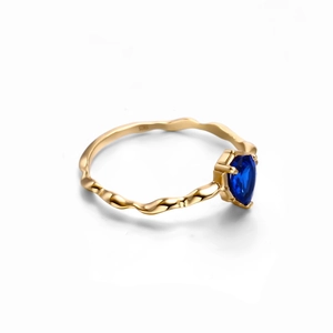 Detalle de anillo de plata 925 con banda ondulada y piedra de zafiro azul corte pera