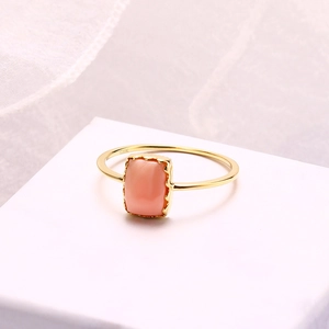 Vue macro d'une bague en or 10K avec pierre rectangulaire en nacre rose-orange