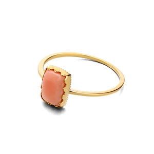 Détail de la bague dorée avec pierre en nacre rose et sertissage à bordure ondulée