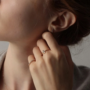 Nahaufnahme von minimalistischem Goldschmuckset mit Baguette-Zirkon-Ohrsteckern und Ringen