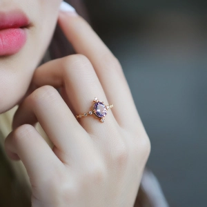 Dettaglio dell'anello in argento S925 dorato con ametista viola ovale sulla mano