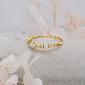 Gedetailleerde weergave van S925 vergulde ring met witte opaal en fijne gravures op de band