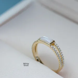 Macro detail of gold plated silver ring with rectangular white mother of pearl and zircons