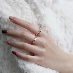 Close-up of dual-layer gold rings with amber and pearl stones on white faux fur