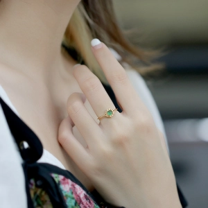 Detailed view of a vintage 14K gold ring with green agate on model's finger