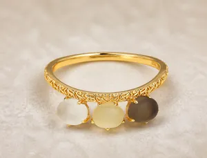 Detalle de anillo retro de plata 925 bañada en oro con patrones florales y tres cristales