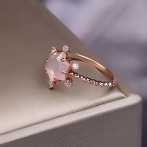 Nahaufnahme von S925 Silberring in Roségold mit sternförmigem Rosenquarz und Kordelband