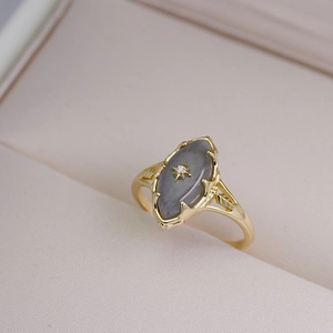 Detailed macro of S925 gold-plated ring featuring grey moonstone and star engraving