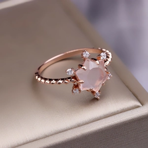 Makroaufnahme eines roségoldenen Stern-Rosenquarz-Rings mit gedrehter Ringschiene
