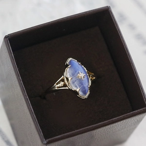 Vintage gold ring with marquise blue moonstone and star motif in a dark brown gift box