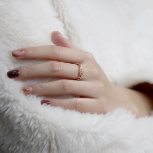 Detalle de anillo vintage en plata S925 dorada con piedra de luna rosa en la mano