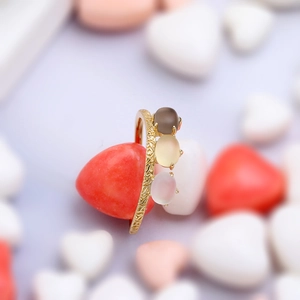 Detalle de anillo de plata 925 bañado en oro con tres cristales naturales y grabado vintage