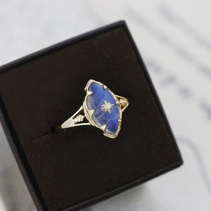 Detail of vintage gold ring with marquise labradorite stone and star engraving