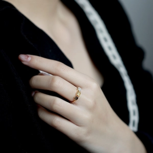 Detalle de anillo de plata 925 bañada en oro con tres piedras naturales sobre el dedo