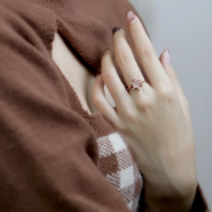 Detailansicht eines roségoldenen Stern-Quarzrings mit Diamanten an der Hand