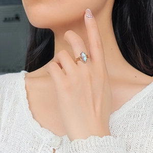 Close-up of gold S925 silver ring with marquise labradorite and star motif on finger
