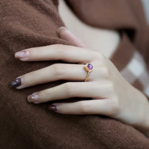 Detail of vintage 925 silver gold-plated ring with purple zircon and twisted band