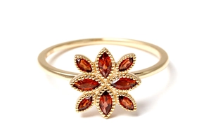 Macro shot of gold-plated silver flower ring featuring red marquise garnet petals and beads