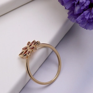 Macro detail of 925 silver gold-plated ring with red pomegranate flower petals