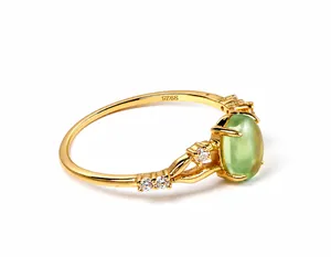 Detailed macro view of S925 sterling silver stamp on a gold-plated green gemstone ring
