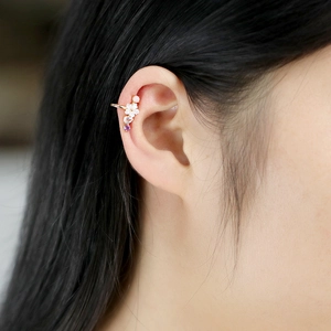 Detail showing natural shell flower ear cuff with pink and purple gemstones on ear