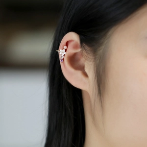 Detail of floral ear bone clip with pink and purple gems on a female model