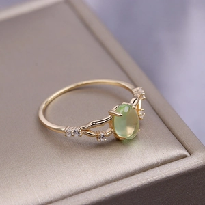 Close-up of a 925 sterling silver gold-plated ring with a green prehnite gemstone