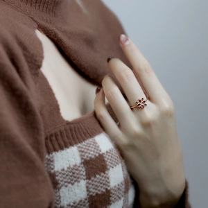 Close-up of 925 silver gold-plated ring with garnet flower worn by a model
