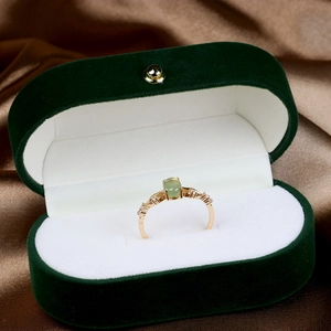 Detailed shot of a gold-plated 925 silver ring with oval green prehnite on velvet