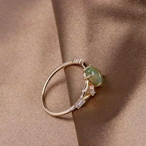 Detailed macro view of 925 silver gold-plated ring with oval green prehnite and zircon