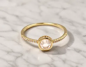 Macro detail of gold-plated silver ring featuring pink crystal and zircon pave settings