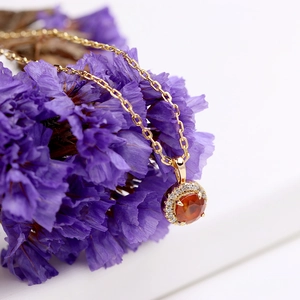 Macro view of gold S925 silver necklace pendant with orange garnet and white zircon