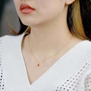 Close-up of S925 silver necklace featuring an orange garnet pendant with halo diamonds