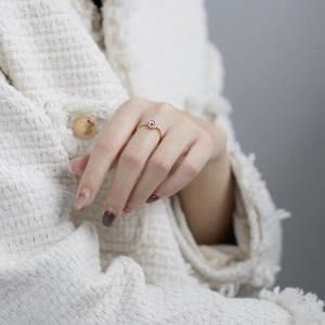 Detaillierte Nahaufnahme eines Goldrings mit violettem Edelstein und Diamanten an der Hand
