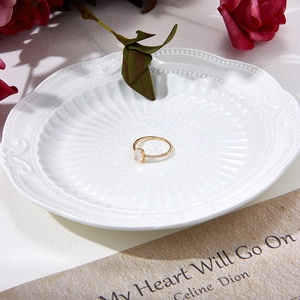 Close-up of a silver natural moonstone ring with gold plating on a floral plate