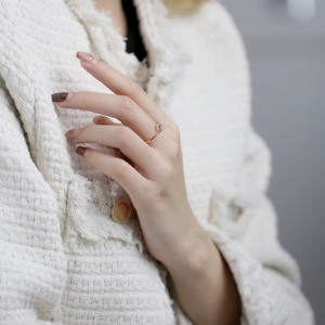Detailansicht eines zierlichen Goldrings mit Edelstein am Finger für einen edlen Look