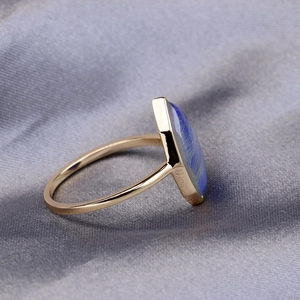 Macro shot of s925 gold-plated ring showing marquise blue stone and silk texture detail