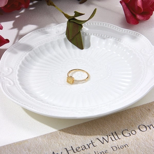 Détail d'une bague en or 14K avec quartz rutilé jaune sur une assiette en porcelaine