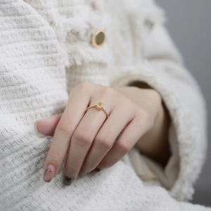 Gros plan d'une bague de luxe en or avec cristal jaune et pierres blanches au doigt
