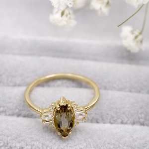Primer plano de un anillo de mariposa dorado con cuarzo ahumado marquise y diamantes