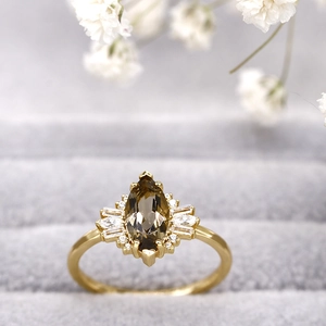 Primer plano detallado de un anillo de cuarzo ahumado talla marquesa y circonitas finas