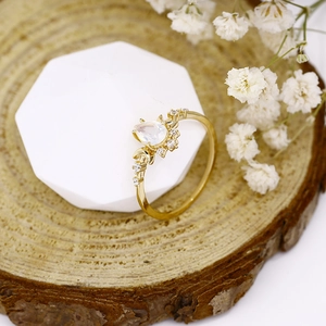 Detail of pear-cut opal ring with crescent moon design on a wooden display block