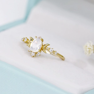 Macro detail of S925 sterling silver ring with pear-cut opal and moon accents