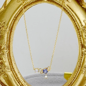 Dettaglio della collana in argento S925 placcato oro con ciondoli a stella e pietra blu